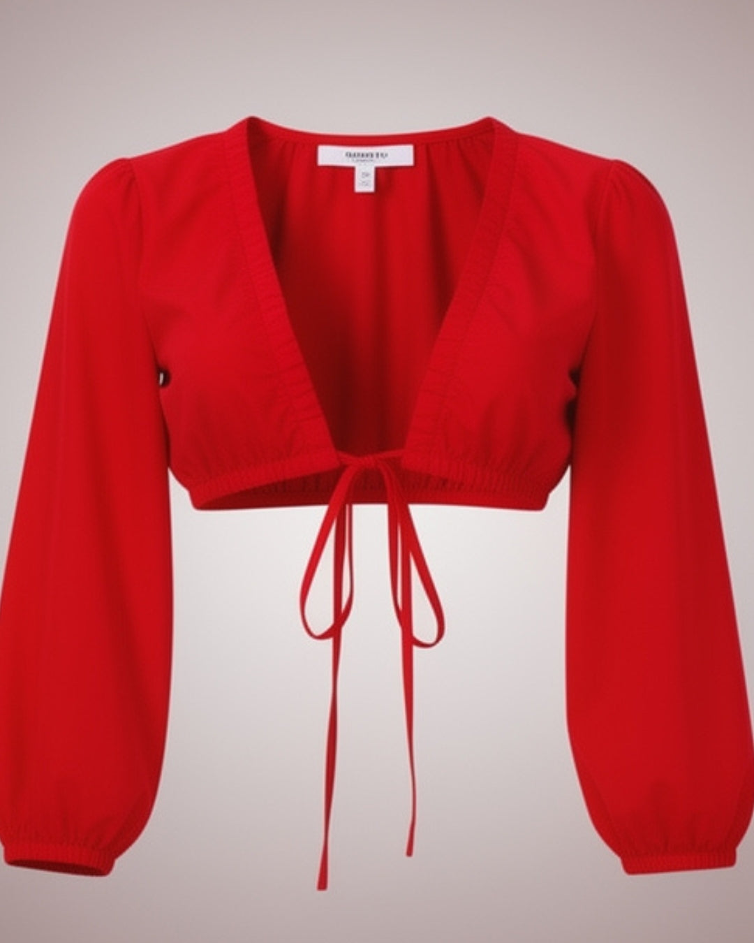 Veloura — top corto rojo con lazo frontal y mangas abullonadas