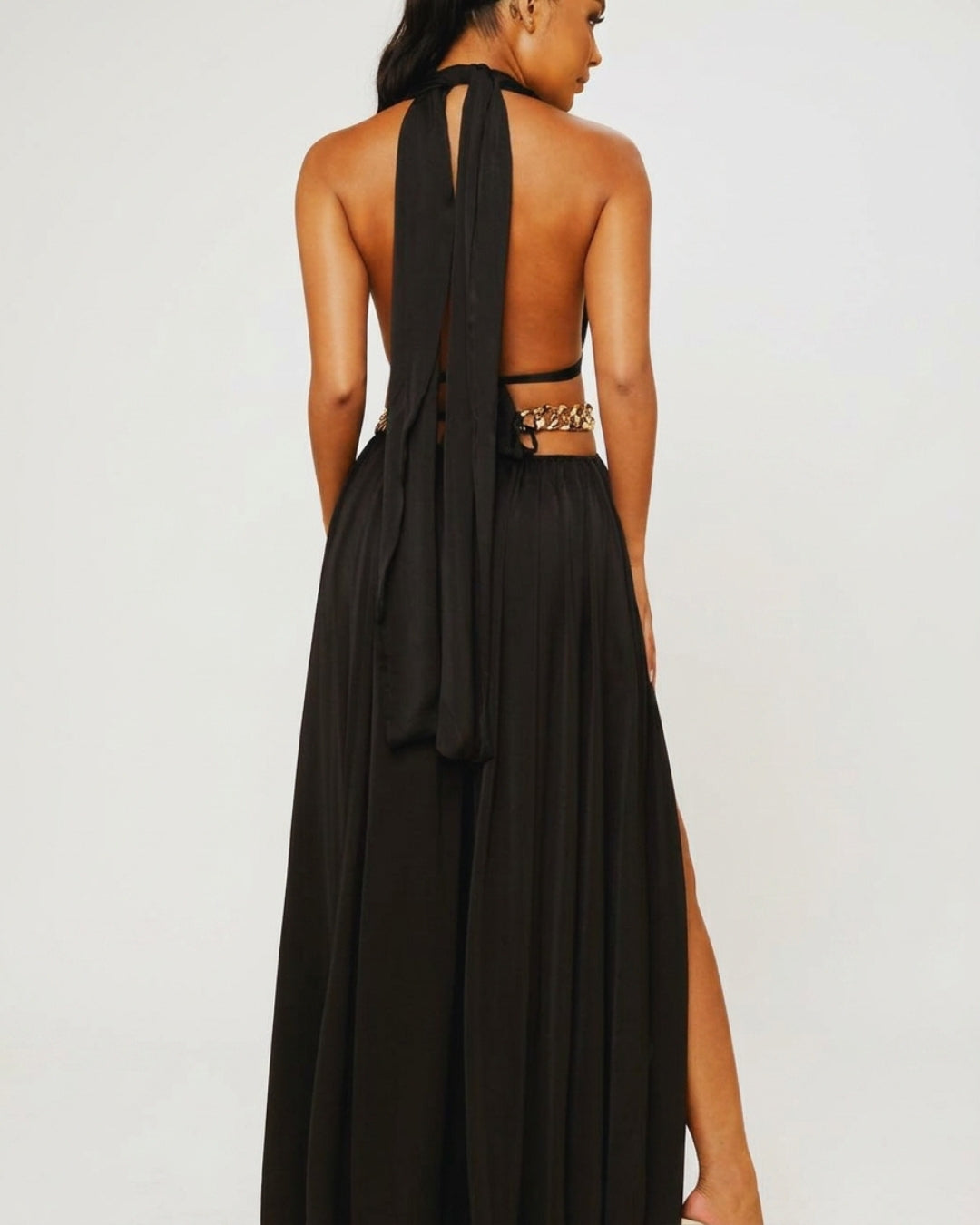 Calyra — vestido negro con cadenas doradas y aberturas elegantes